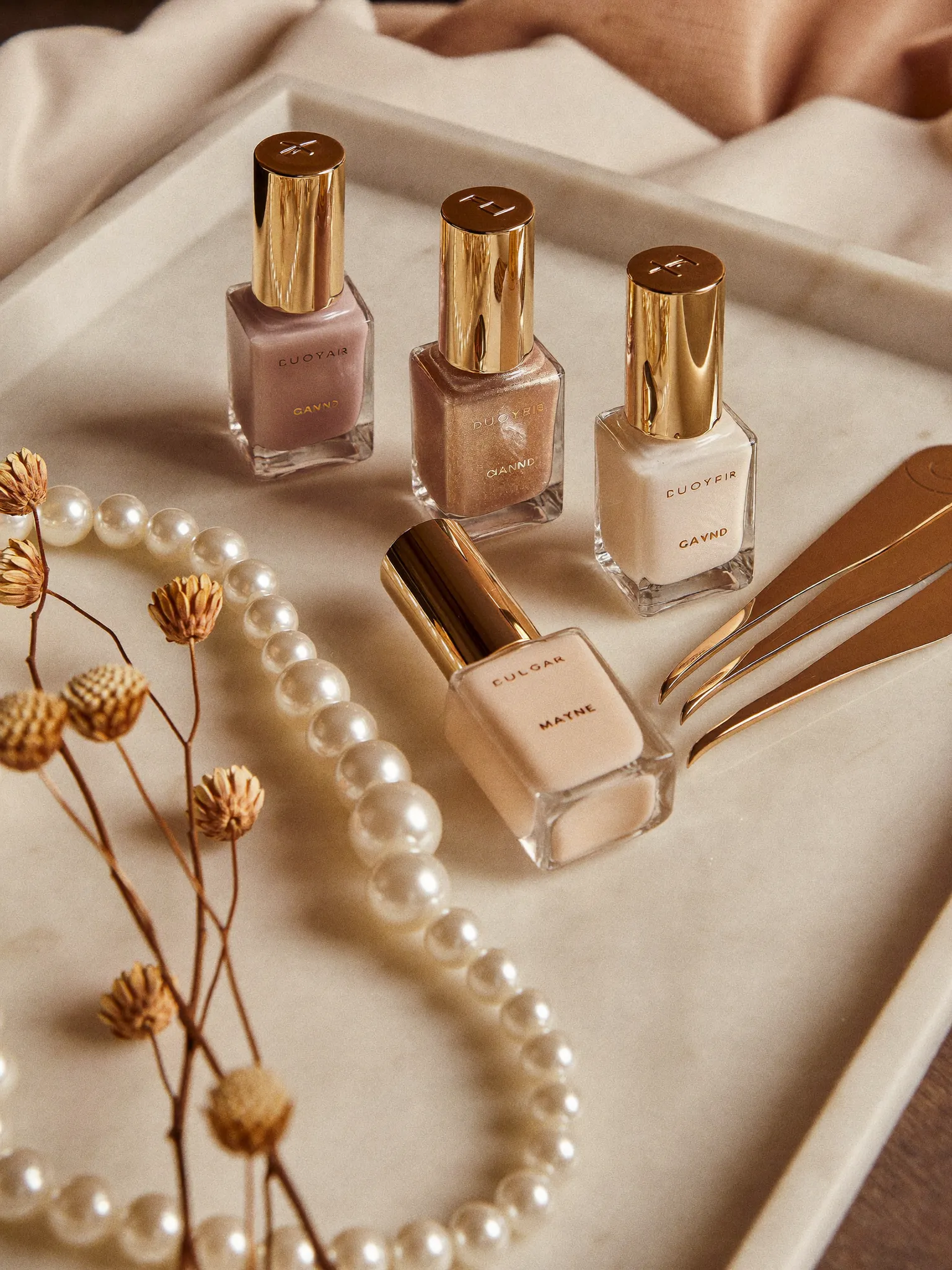 Premium gel polish bottles and gold tools arranged on a marble tray