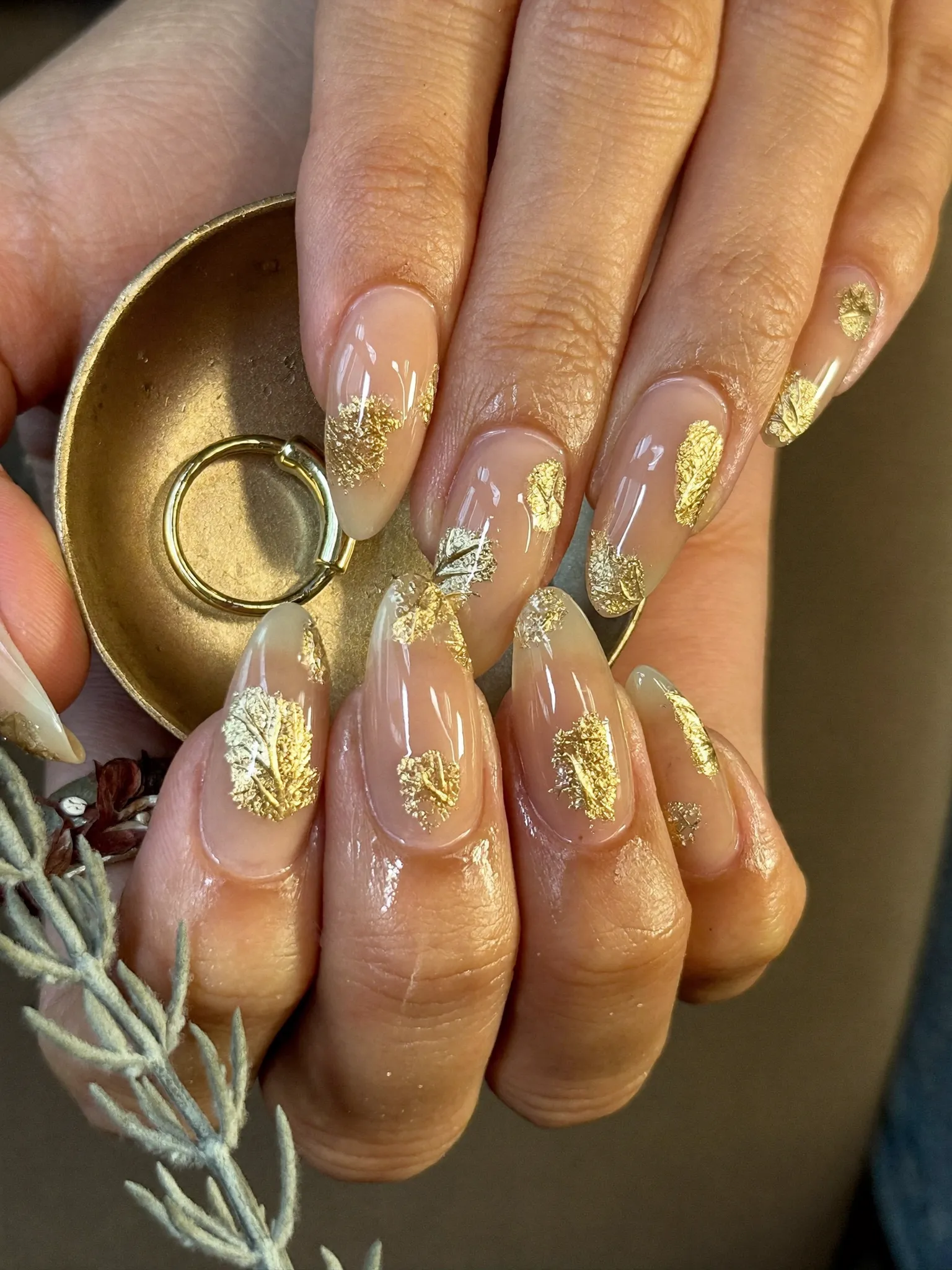 Almond nails with gold leaf accents over a champagne base